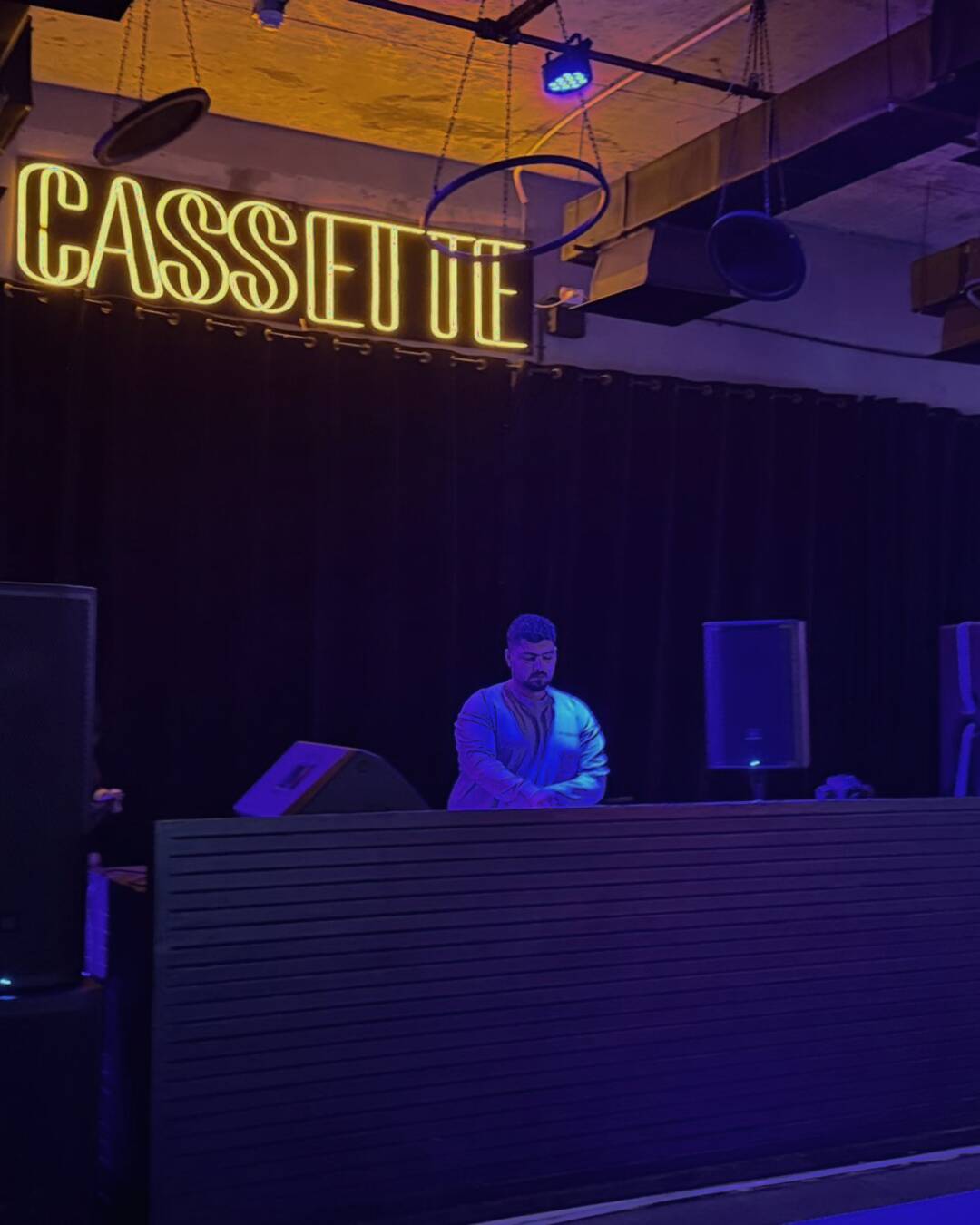 The Cassette floor under purple neon — New Alamein beachfront